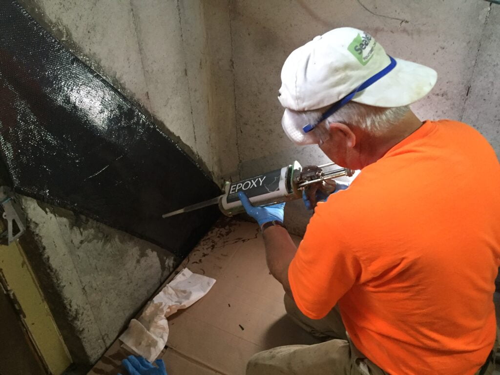 Applying a carbon fiber sheet to a foundation crack