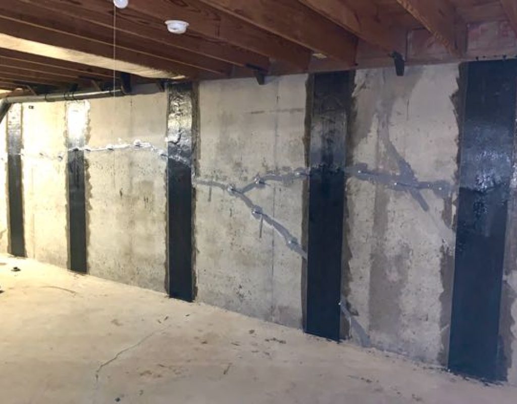 A bowed basement wall reinforced with carbon fiber straps and steel braces