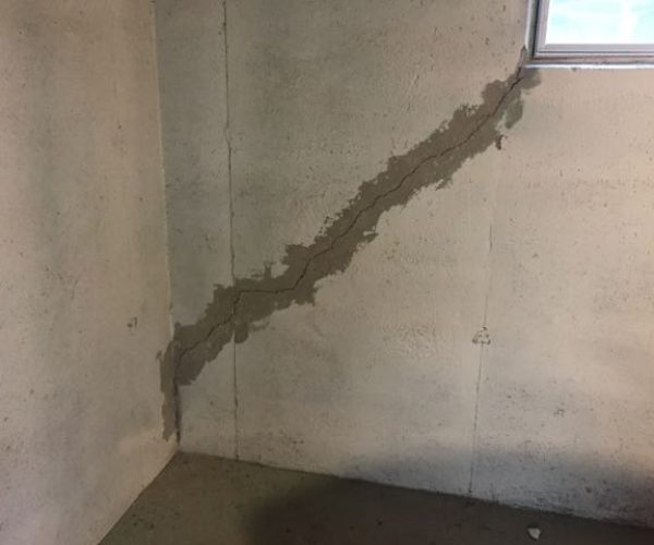 A completed crack injection repair on a basement retaining wall