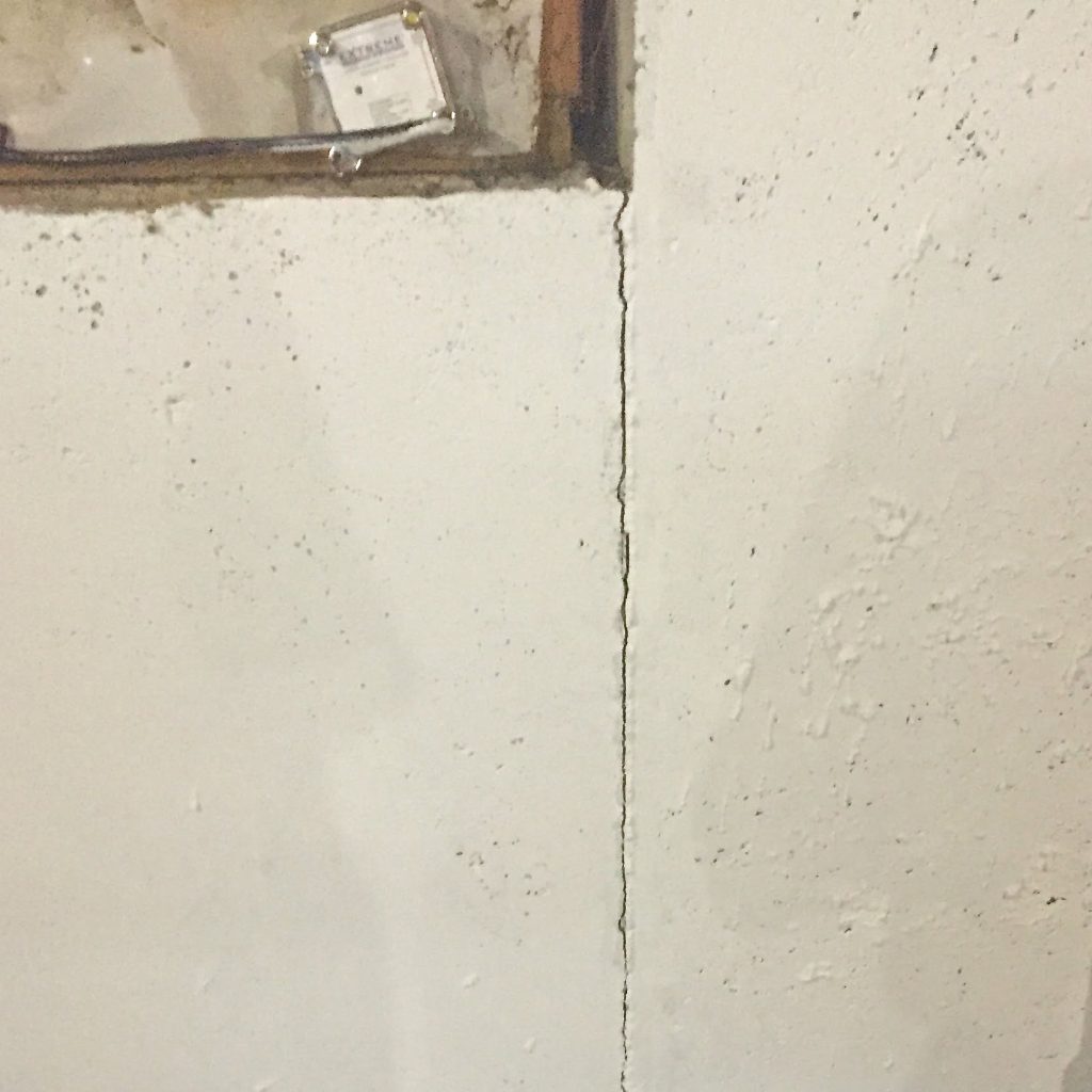 A visible crack in a basement wall before repair