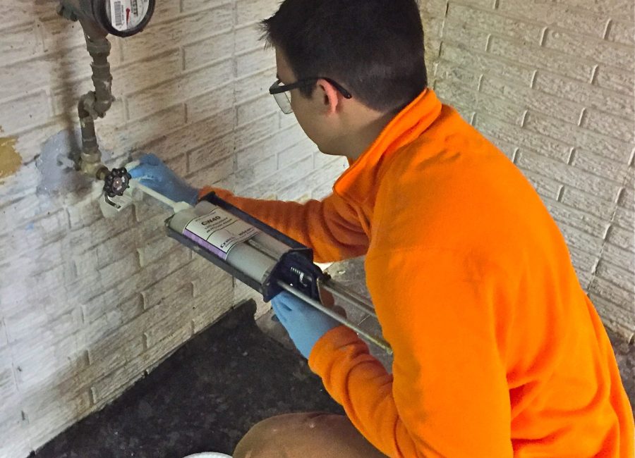 A Sealed LLC technician completing the final filling steps of a leak repair